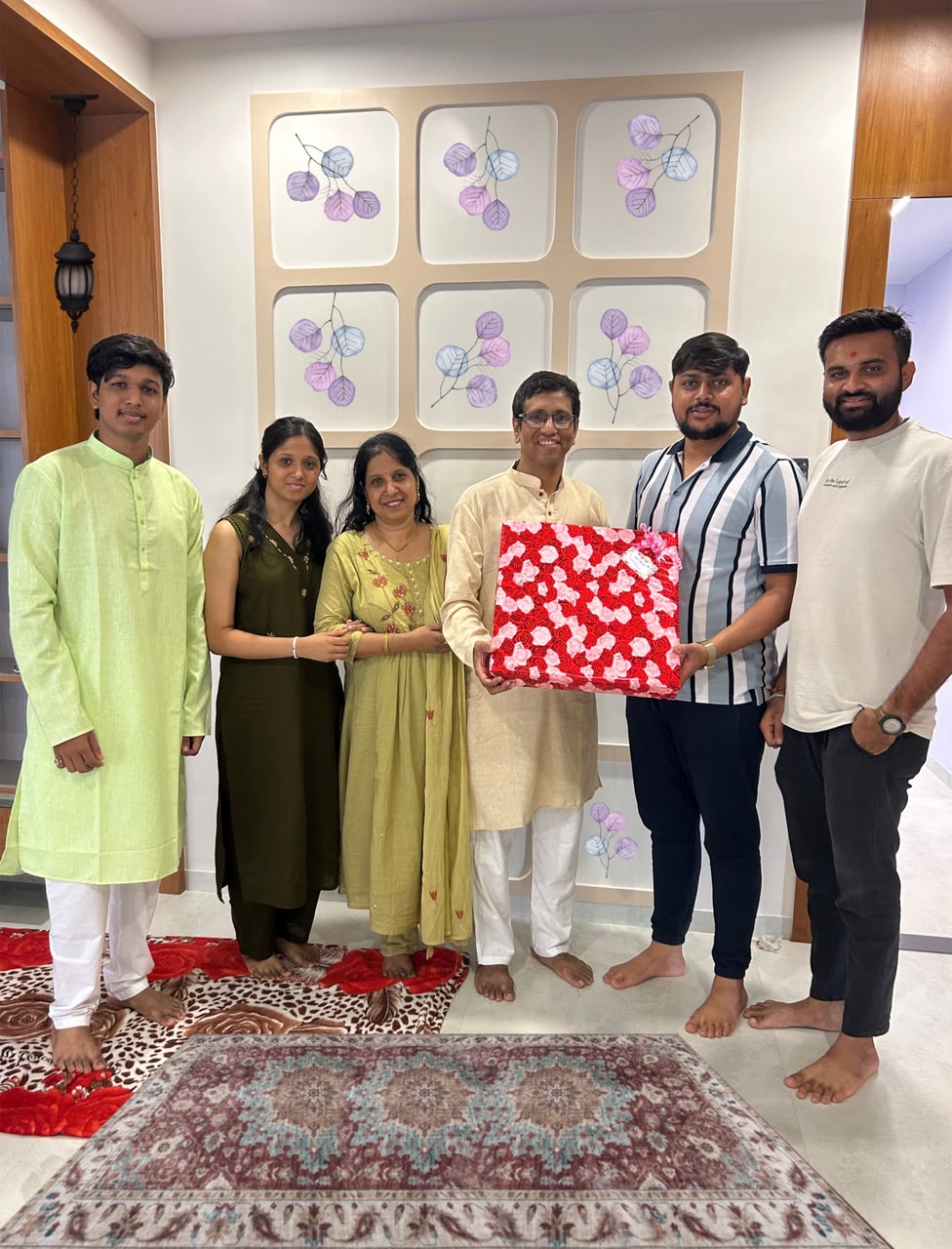 Family celebrating with the Sarvamangal team and a floral-wrapped gift